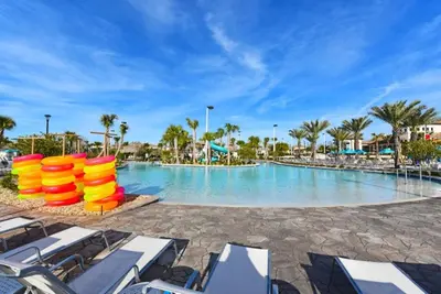 a pool at a resort with chairs and palm trees at 891Pbeach Amazing Champions Gate 8 Bedroom 5 Bed Villa in Orlando