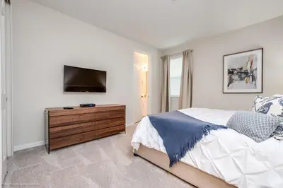 a bedroom with a bed and a dresser with a television at Solara Resort 9 Bedroom 6 Bathroom Resort Villa Villa in Orlando