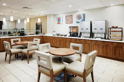 a restaurant with tables and chairs and a counter at Staybridge Suites Orlando Royale Parc Suites by IHG in Orlando