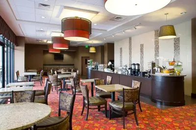 a restaurant with tables and chairs and a bar at Ramada Plaza by Wyndham Orlando Resort & Suites Intl Drive - Newly Renovated! in Orlando