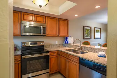 a kitchen with stainless steel appliances and wooden cabinets at FantasyWorld Resort in Kissimmee