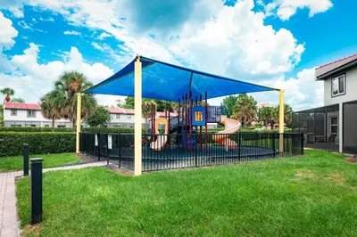 a playground with a blue canopy in a park at FantasyWorld Resort in Kissimmee