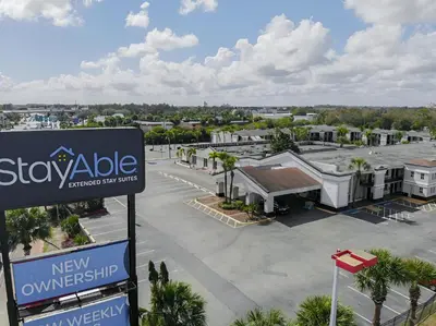 a sign in a parking lot next to a building at Stayable Orlando at Florida Mall in Orlando