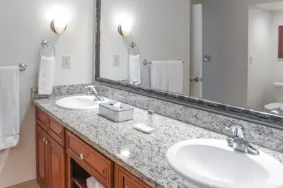 a bathroom with two sinks and a large mirror at Hilton Vacation Club Polynesian Isles Kissimmee in Kissimmee