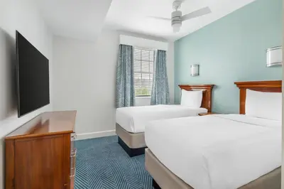 a hotel room with two beds and a flat screen tv at Hilton Vacation Club Grand Beach Orlando in Orlando