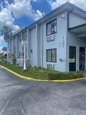 a white building on the side of a street at Ambassador Inn in Kissimmee