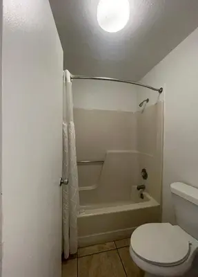 a bathroom with a toilet and a bath tub and a toilet at Ambassador Inn in Kissimmee