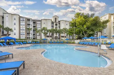 a swimming pool with blue chairs and buildings at Hilton Vacation Club Grande Villas Orlando in Orlando