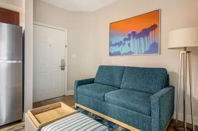 a living room with a blue couch and a refrigerator at Hilton Vacation Club Grande Villas Orlando in Orlando