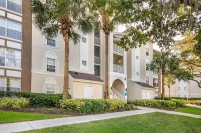 a large building with palm trees in front of it at Hilton Vacation Club Grande Villas Orlando in Orlando