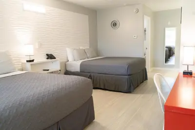 a hotel room with two beds and a desk at Disney 12 minutes for family, Pool and parking FREE in Kissimmee