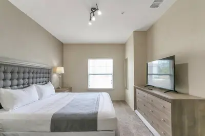 a bedroom with a bed and a flat screen tv at Amazing Townhouse in gated community 10' to Disney! in Kissimmee