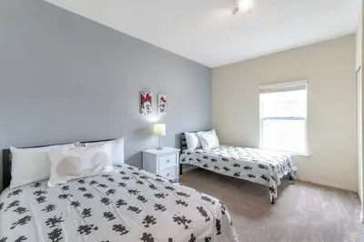 a bedroom with a bed and a nightstand and a window at Amazing Townhouse in gated community 10' to Disney! in Kissimmee