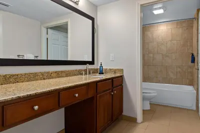 a bathroom with a sink and a mirror and a toilet at Club Wyndham Cypress Palms in Kissimmee