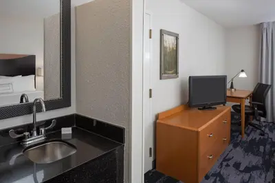 a hotel room with a bathroom with a sink and a television at Fairfield Inn & Suites by Marriott Orlando Lake Buena Vista in Orlando