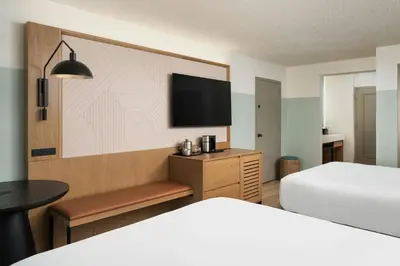 a hotel room with two beds and a flat screen tv at Sheraton Orlando Lake Buena Vista Resort in Orlando