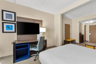 a hotel room with a bed and a desk and a tv at Comfort Suites Near Universal Orlando Resort in Orlando