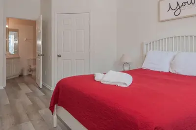a bedroom with a red bed with two towels on it at 2785AL-SVH Brand New Apartment! in Orlando