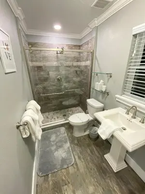 a bathroom with a shower and a toilet and a sink at Mickeys Pearl - Phenomenal 7BR with 4 Master Suites Privacy Pool & Hot Tub Gas BBQ - 2 miles to Disney in Orlando