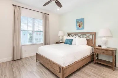 a bedroom with a large bed and a window at Sandcastles & Sunshine Cottage With Private Pool Near Disney With Margaritaville Resort & Island H20 Access - 8025Su in Orlando