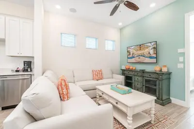 a living room with a couch and a table at Salt Water Cottage Near Disney With Margaritaville Resort & Island H2O Access - 8012Dr in Orlando