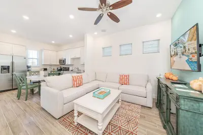 a living room with a couch and a table at Salt Water Cottage Near Disney With Margaritaville Resort & Island H2O Access - 8012Dr in Orlando
