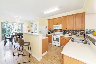 a kitchen with white appliances and a dining room at Lovely Disney Vacation House in Orlando