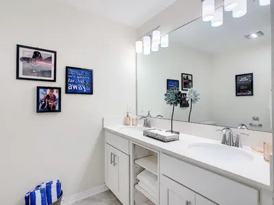 a bathroom with a sink and a large mirror at Splendid Thematic 2BR with Waterpark in Kissimmee
