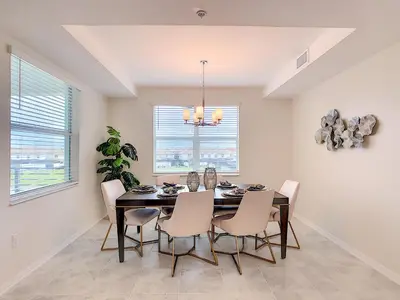 a dining room with a black table and chairs at Splendid Thematic 2BR with Waterpark in Kissimmee