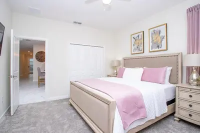 a bedroom with a large bed with pink pillows at Gorgeous 5 Bd Single Family Close to Disney @ Storey Lake Resort 2734 in Kissimmee