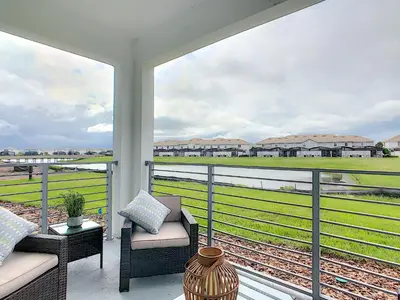 a balcony with a view of a train yard at Lakeview Themed 2BR Condo with Waterpark Access in Kissimmee