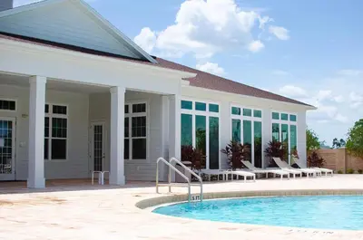 a house with a swimming pool in front of a building at Great townhouse in great luxurious community, poolgym Close to Disney! in Kissimmee