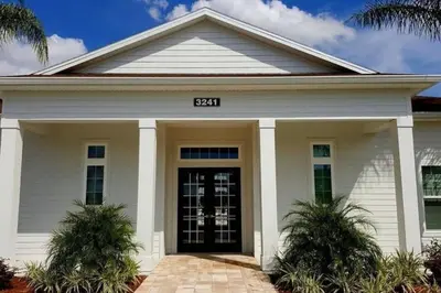 a white house with a black door at Great townhouse in great luxurious community, poolgym Close to Disney! in Kissimmee
