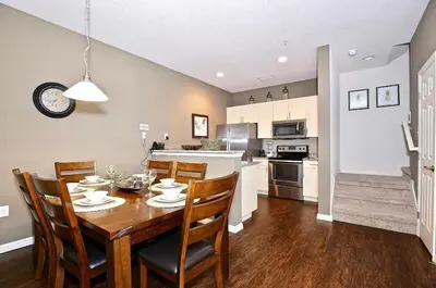 a kitchen and dining room with a wooden table and chairs at Great townhouse in great luxurious community, poolgym Close to Disney! in Kissimmee