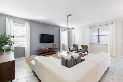 a living room with a white couch and a tv at 2957 FS - Luxury Oasis: 6BR Villa Pool Game in Kissimmee