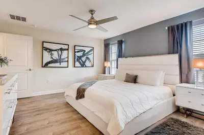 a bedroom with a white bed and a ceiling fan at 4808 LL Magical 4BR Disney Townhome Pool in Kissimmee