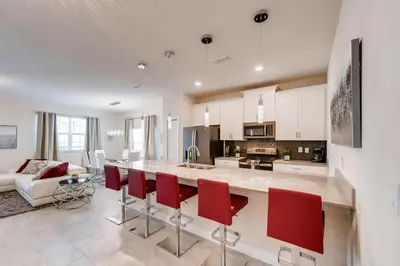 a large kitchen with red chairs and a counter top at 4825 LL - Storey Lake in Kissimmee