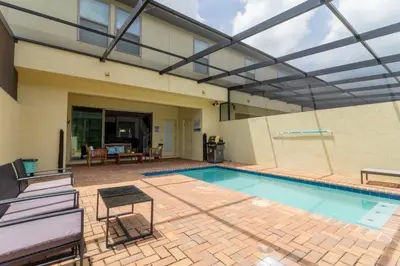 a swimming pool with a retractable roof at 8843 GC Windsor at Westside Luxury 5 BR Townhome in Kissimmee