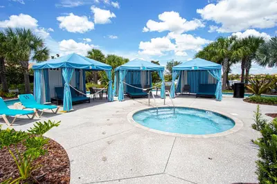 a group of blue tents with a pool at 8843 GC Windsor at Westside Luxury 5 BR Townhome in Kissimmee