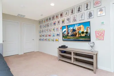 a room with a wall with pictures on it at 8843 GC Windsor at Westside Luxury 5 BR Townhome in Kissimmee