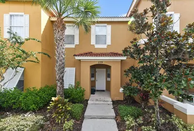 a building with a palm tree in front of it at 139PBD-SVH Lovely New Townhome! in Kissimmee