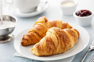 two croissants on a white plate on a table at Sheraton Orlando North in Orlando