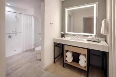 a bathroom with a sink and a mirror and a toilet at Sheraton Orlando North in Orlando