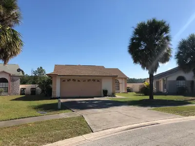 a house with a palm tree and a garage at Laguna Villas in Kissimmee