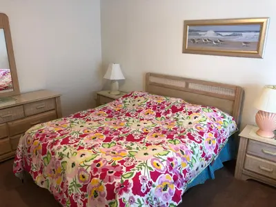 a bedroom with a bed with a floral bedspread at Laguna Villas in Kissimmee