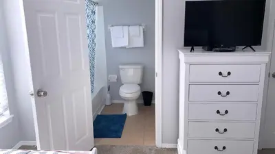 a bathroom with a toilet and a television on a dresser at Disney Holiday Home, Orlando in Kissimmee