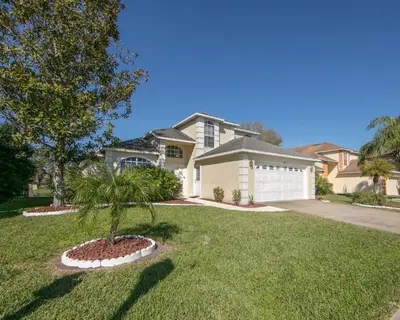 a house with a palm tree in a yard at Mickey's Lake Villa 2 in Orlando