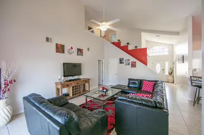 a living room with two leather couches and a tv at Mickey's Lake Villa 2 in Orlando