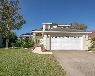 a large house with a white garage at Mickey's Lake Villa 2 in Orlando