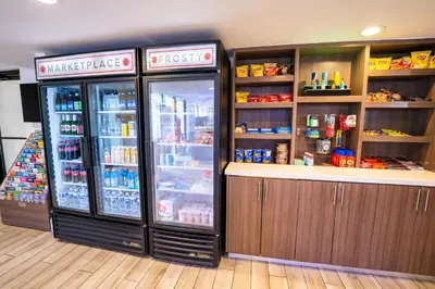 a grocery store with a refrigerator and a counter at Mai Hana Hotel and Suites I Drive-Theme Parks in Orlando